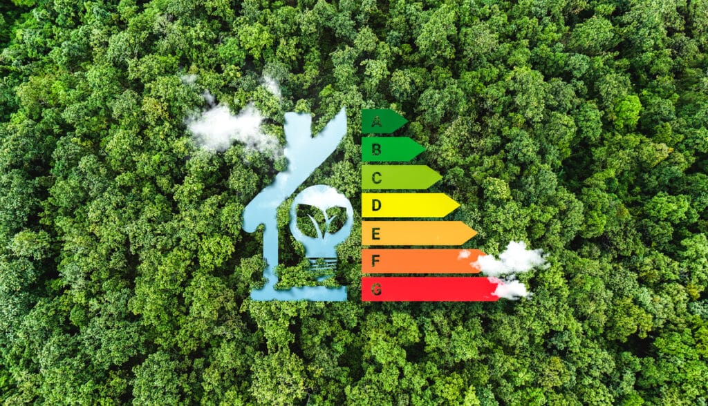 Vue aérienne d'une forêt luxuriante avec une icône de maison bleue intégrant une ampoule verte, à côté d'une échelle d'efficacité énergétique de A à G avec fumée.
